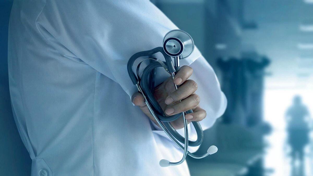 یک پزشک از نمای پشتی که استتوسکوپ خود را در دست دارد